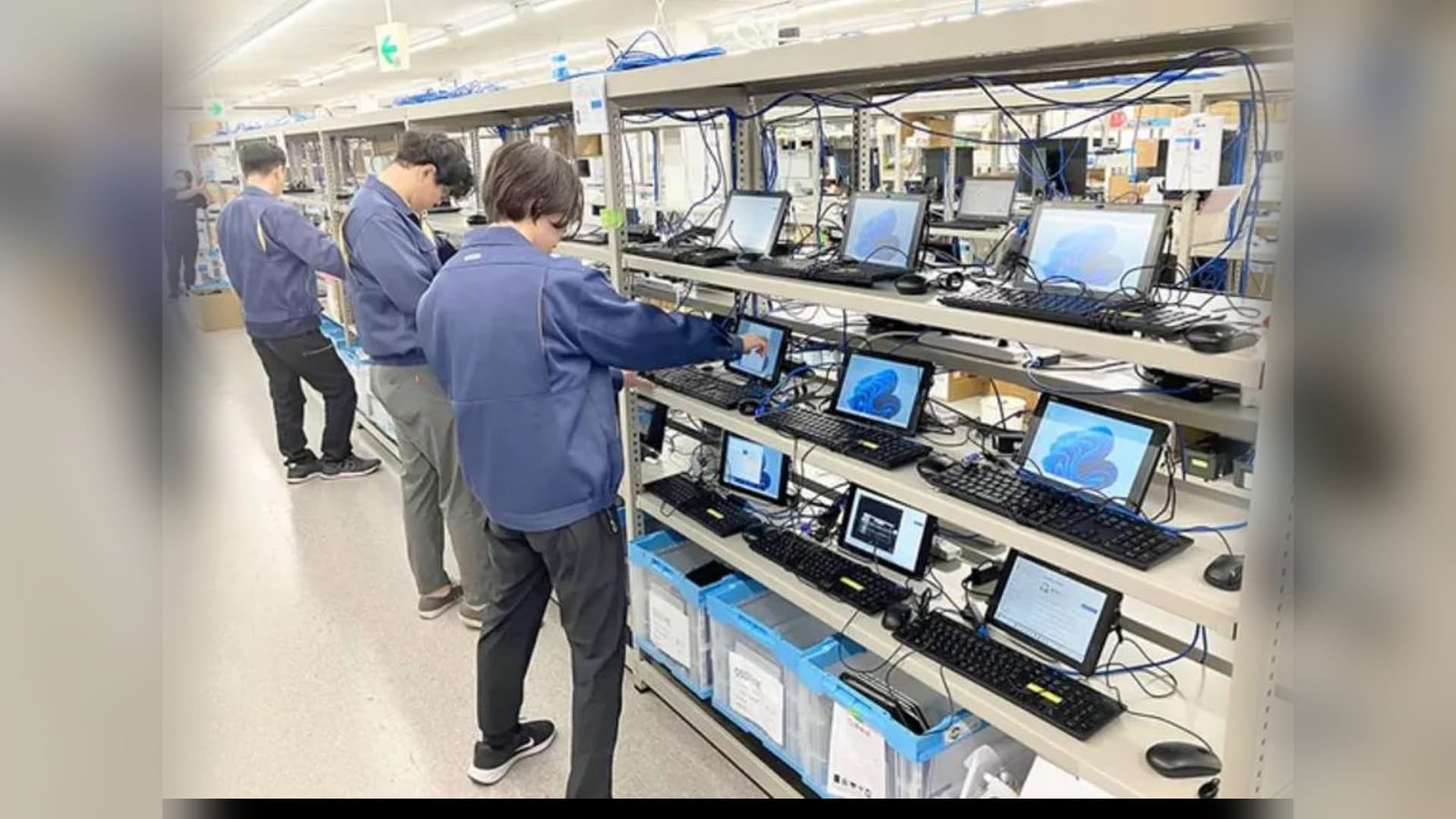 Estações de trabalho com monitores e teclados sendo preparadas e testadas na bancada da Brain