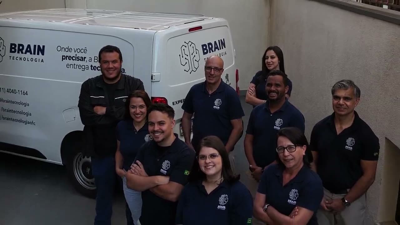 Time da Brain Tecnologia reunido ao lado da van adesivada da empresa
